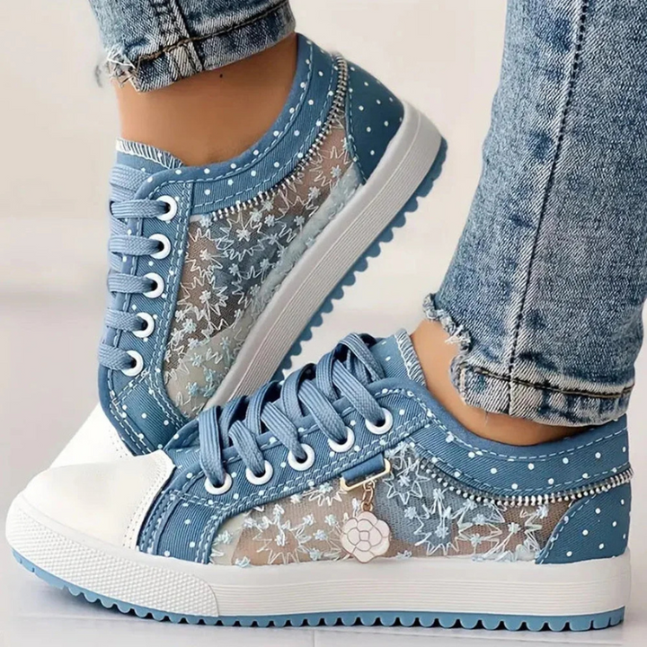 Niebieskie damskie sneakersy z kwiatowym haftem i zawieszką, idealne na co dzień i miejski styl.