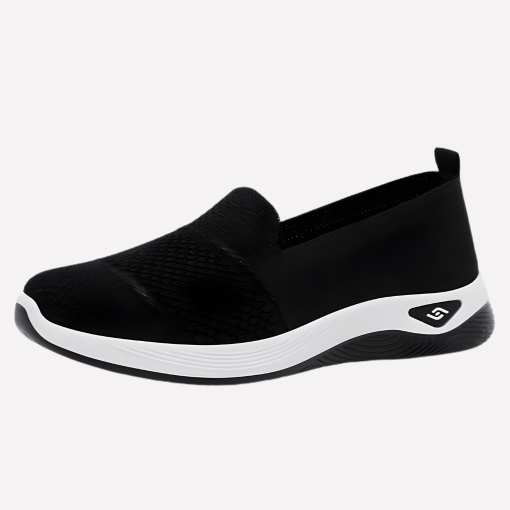 Kobieta w sportowych, białych sneakersach idąca ulicą. Wygodne damskie buty na co dzień, modne obuwie casualowe.