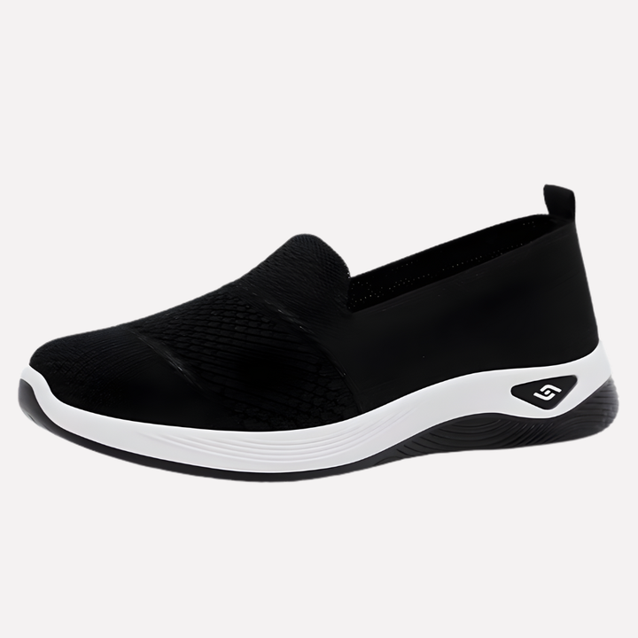 Kobieta w sportowych, białych sneakersach idąca ulicą. Wygodne damskie buty na co dzień, modne obuwie casualowe.