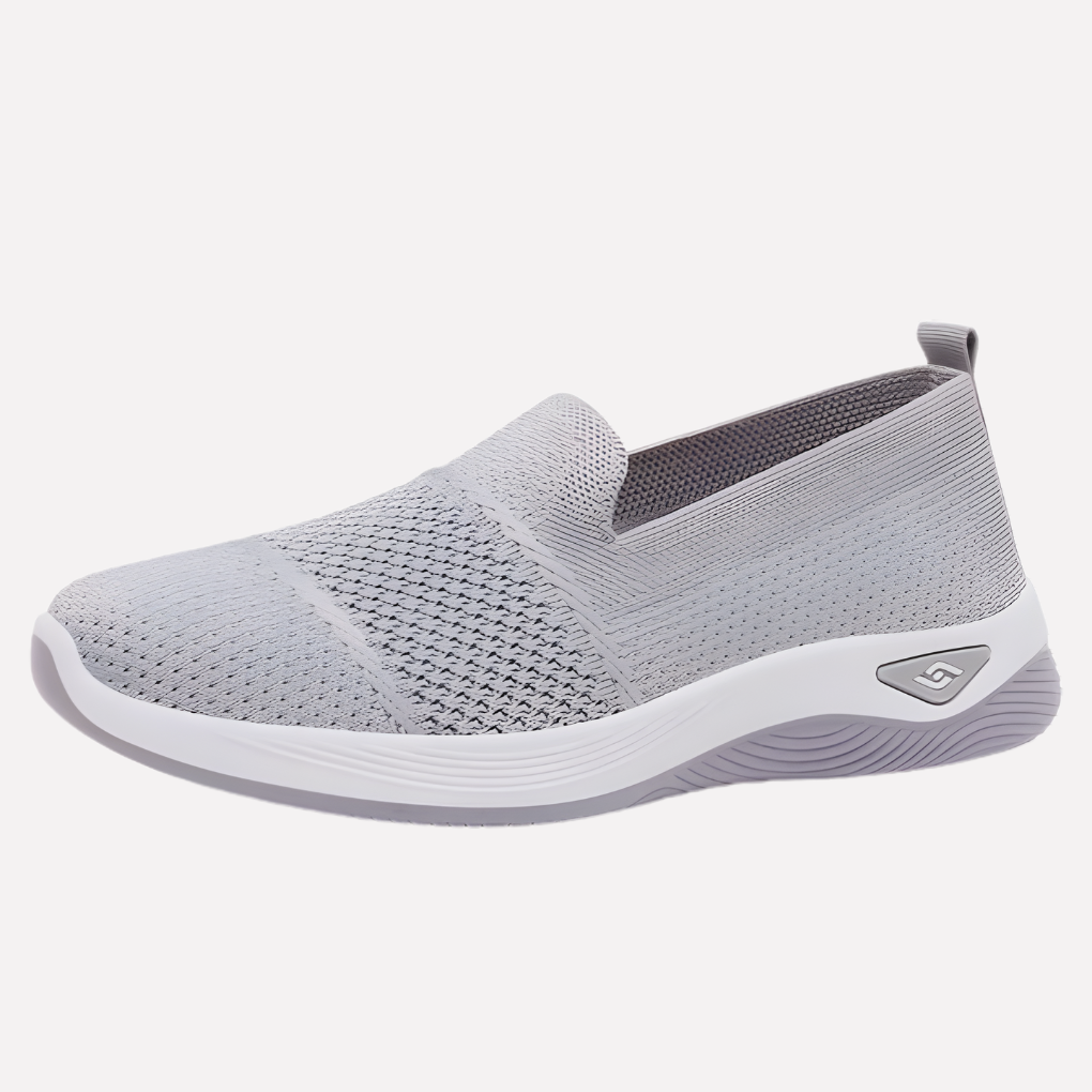 Eleganckie damskie buty sportowe w jasnym kolorze, widok z boku. Modne sneakersy na co dzień do casualowych stylizacji.