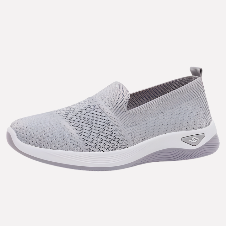 Eleganckie damskie buty sportowe w jasnym kolorze, widok z boku. Modne sneakersy na co dzień do casualowych stylizacji.