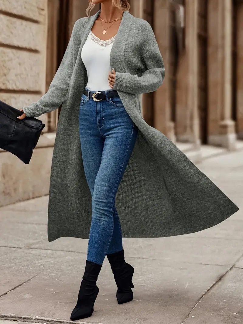 Kobieta prezentująca szary długi kardigan damski. Wiosenny, elegancki sweter narzutka na każdą okazję.