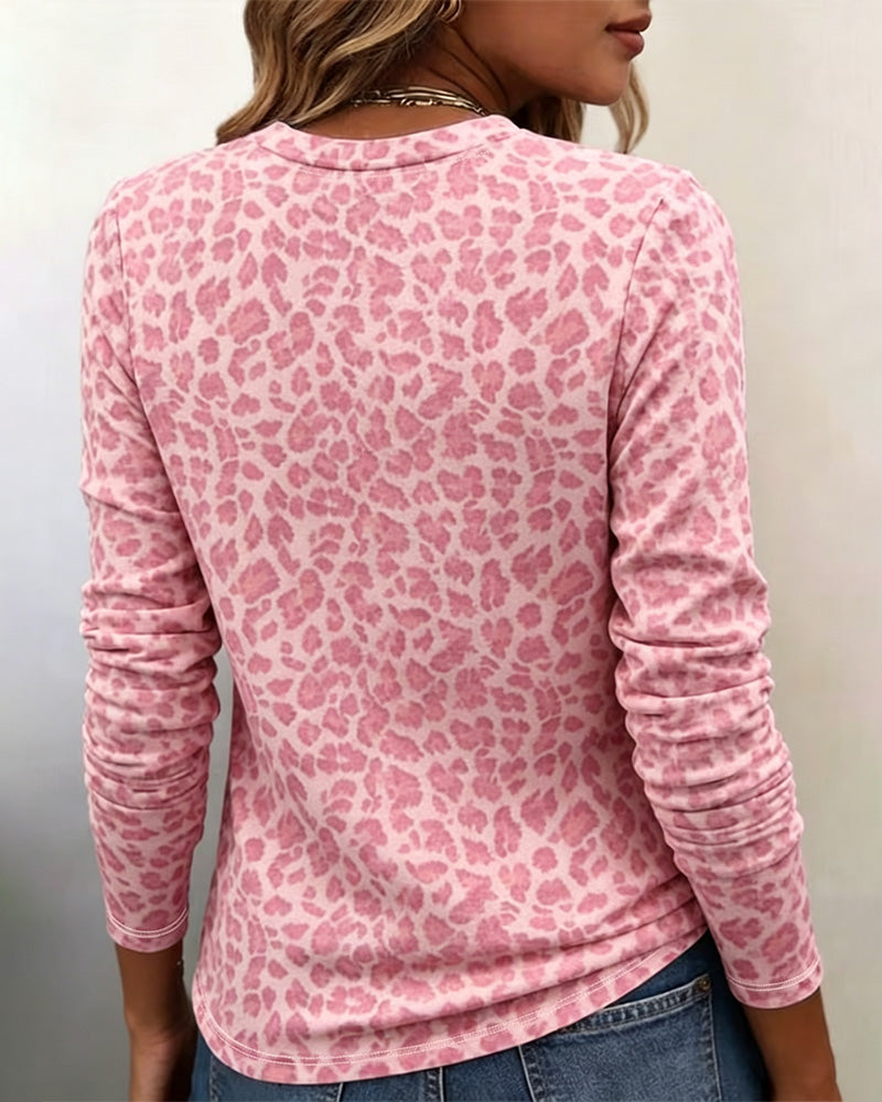 Modny różowy t-shirt damski z długim rękawem i okrągłym dekoltem. Panterkowy wzór zwierzęcy do casualowych stylizacji.