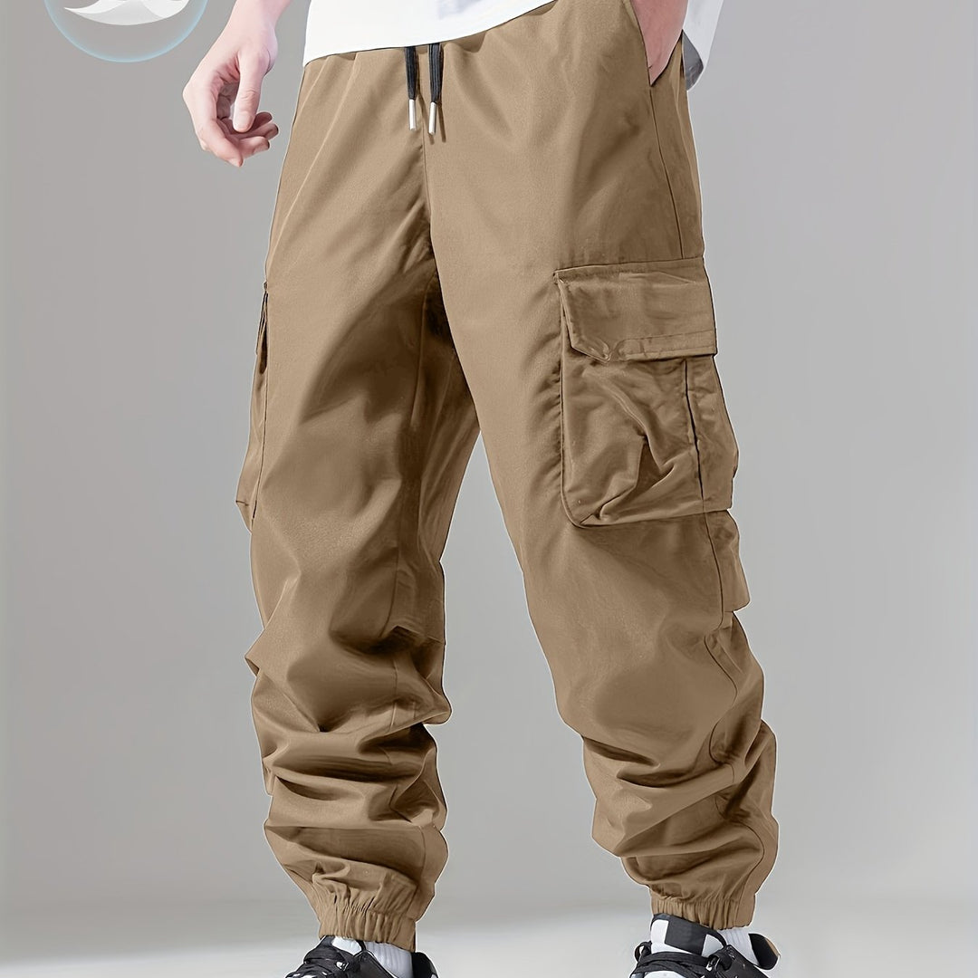 Mężczyzna w modnych spodniach cargo joggerach regular fit, casualowy look na jesień/wiosnę.