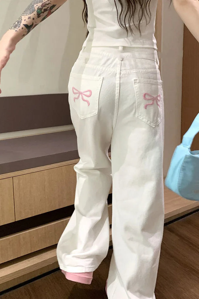Modne białe jeansy damskie wide leg z haftem kokard. Perfekcyjne do casualowych i streetwearowych stylizacji.