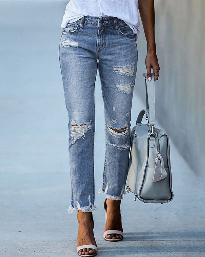 Damskie jeansy slim fit Liora z efektywnymi przetarciami na nogawkach. Stylowe spodnie do codziennych outfitów.
