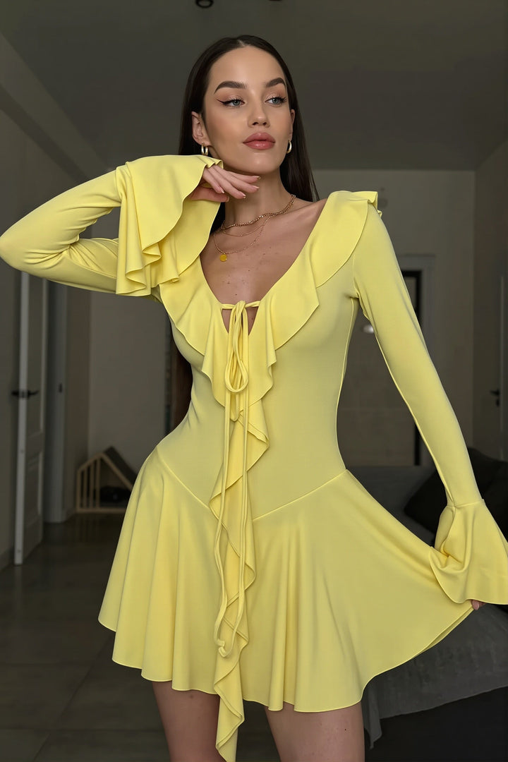 Krótka damska sukienka bodycon z falbaną i wiązaniem. Elegancka, na wyjścia, podkreślająca sylwetkę.