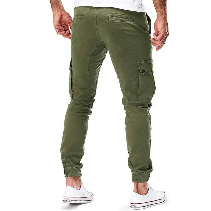 Detail: Pojemne boczne kieszenie w męskich spodniach bojówkach cargo ze ściągaczami. Streetwear miejski.