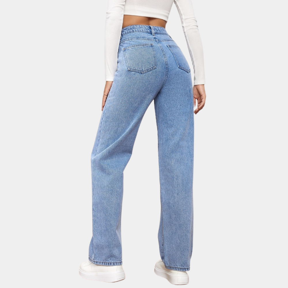 Modelka w stylowych damskich jeansach z wysokim stanem. Proste nogawki, klasyczny krój, granatowy kolor.