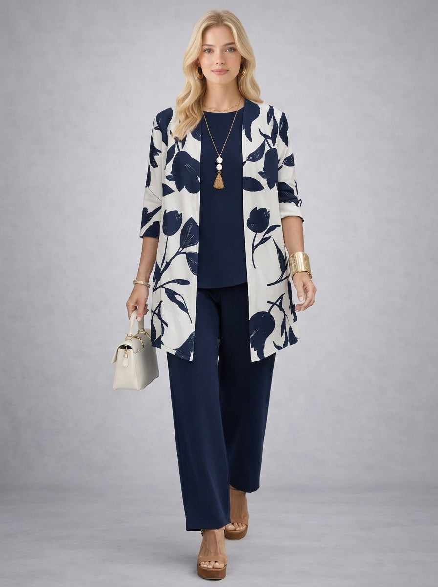 Modelka prezentuje elegancki komplet 3-częściowy: płaszcz, bluzka, spodnie. Casualowy i stylowy look.