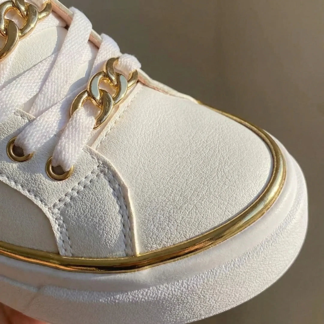 Eleganckie damskie sneakersy na wysokiej platformie ze złotymi zdobieniami. Stylowe obuwie codzienne.