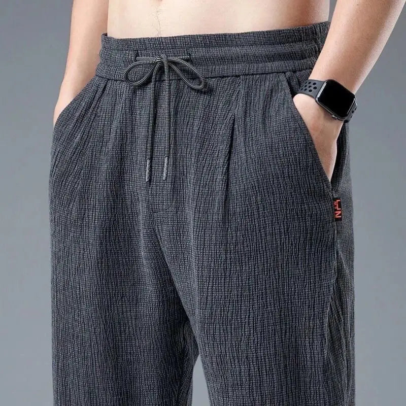 Wygodne męskie spodnie casual z wiązaniem w pasie, zwężanymi nogawkami, świetne do letnich stylizacji streetwear.