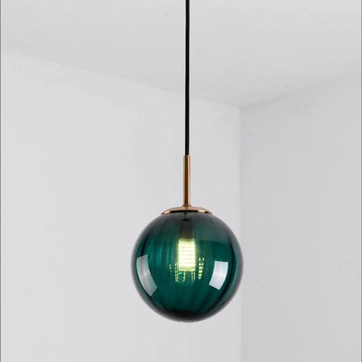 Lampa wisząca z kulistym szklanym kloszem. Nowoczesne oświetlenie sufitowe. Dekoracja, nastrojowe światło.