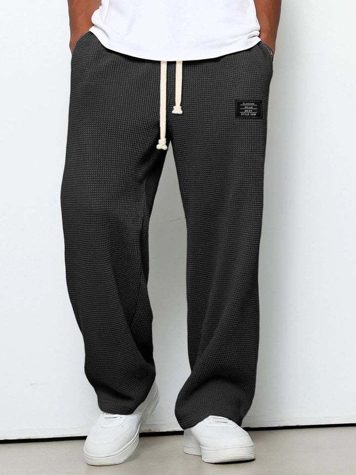 Luźne spodnie męskie casual, widok z tyłu. Wygodne i modne, idealne do streetwearu. Całoroczne.