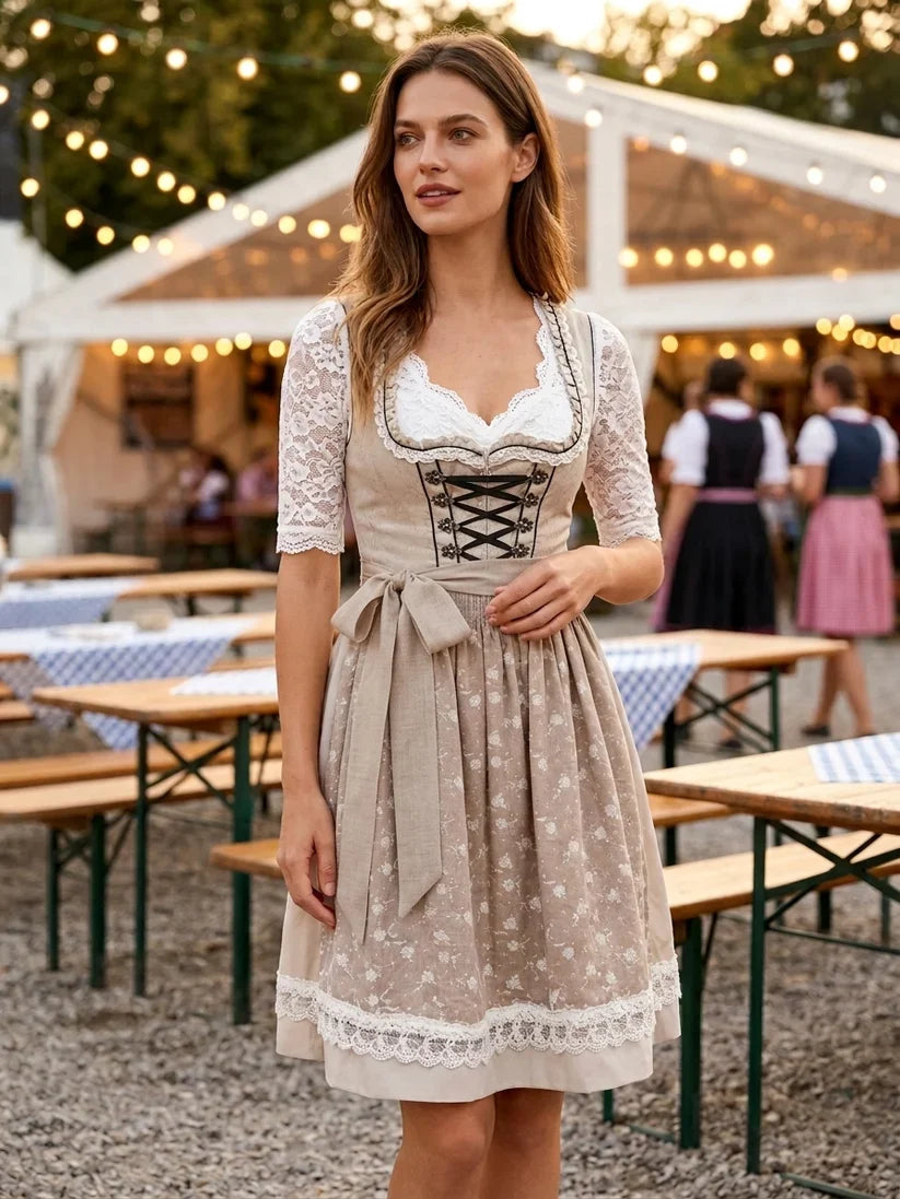 Tradycyjny komplet dirndl damski, beżowo-biała sukienka bawarska z fartuszkiem i bluzką. Na Oktoberfest.