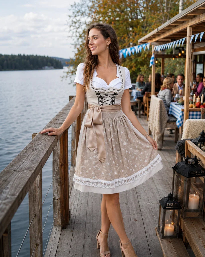 Damski komplet dirndl: beżowo-biała sukienka ludowa, bluzka, fartuszek. Klasyczny strój na Oktoberfest.