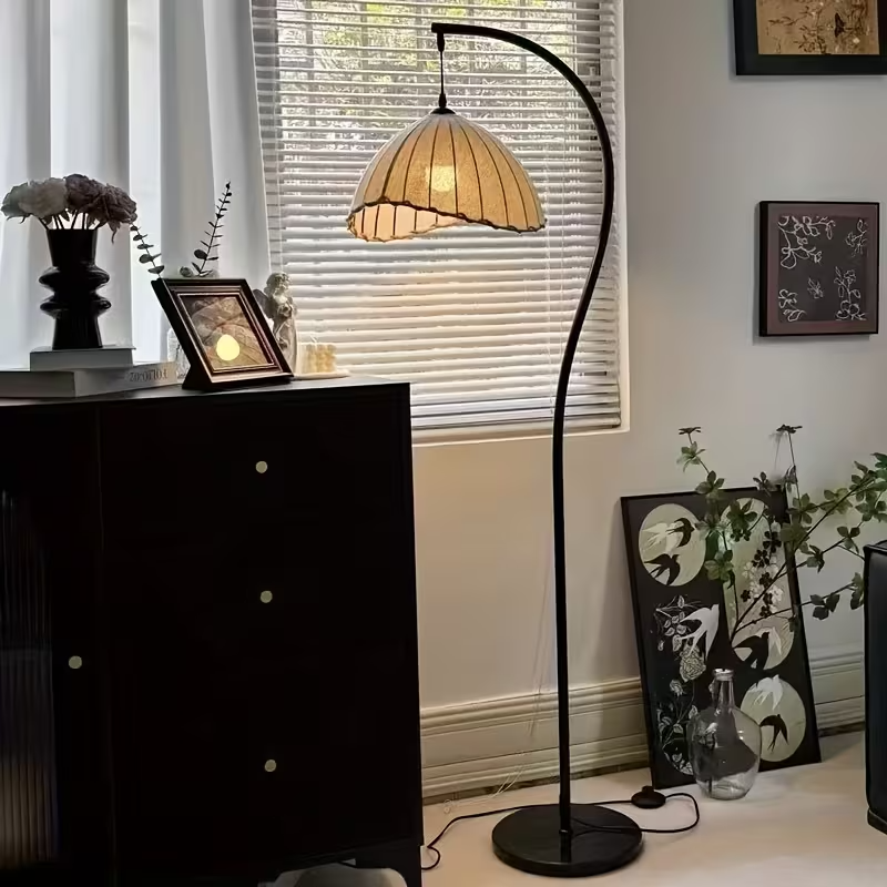 Nowoczesna lampa podłogowa brązowa, stylizowana na kopułę, z elegancką zakrzywioną podstawą, do wnętrz.