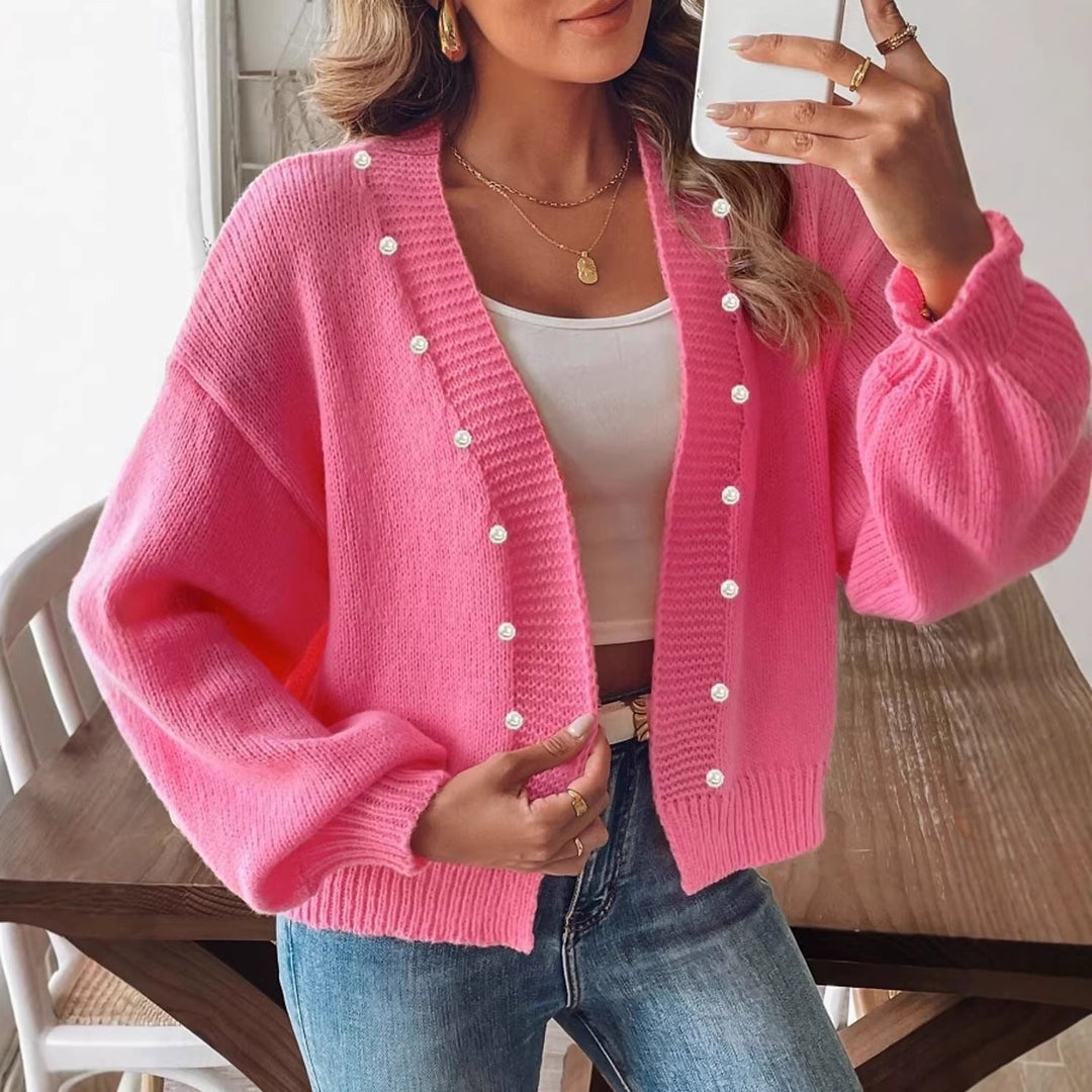 Elegancki kardigan damski z dekoltem V i perłowymi guzikami. Modny sweter oversize z bufiastymi rękawami.
