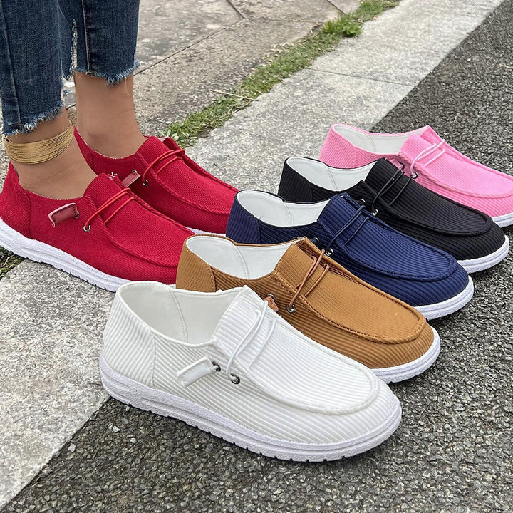 Kobieta w sportowych sneakersach wsuwanych z prążkowaną strukturą. Lekkie buty na spacer.
