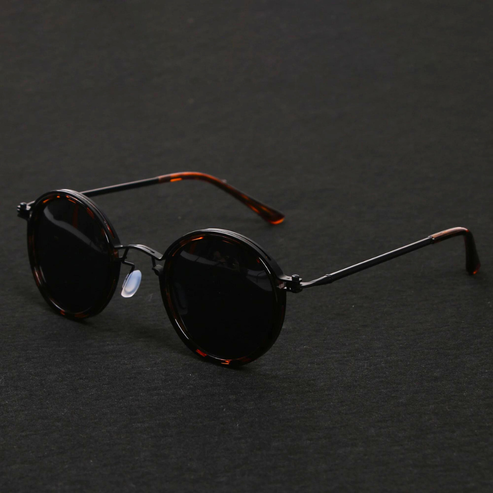 Modne, okrągłe okulary przeciwsłoneczne unisex z ciemnymi soczewkami i ochroną UV. Elegancki dodatek.