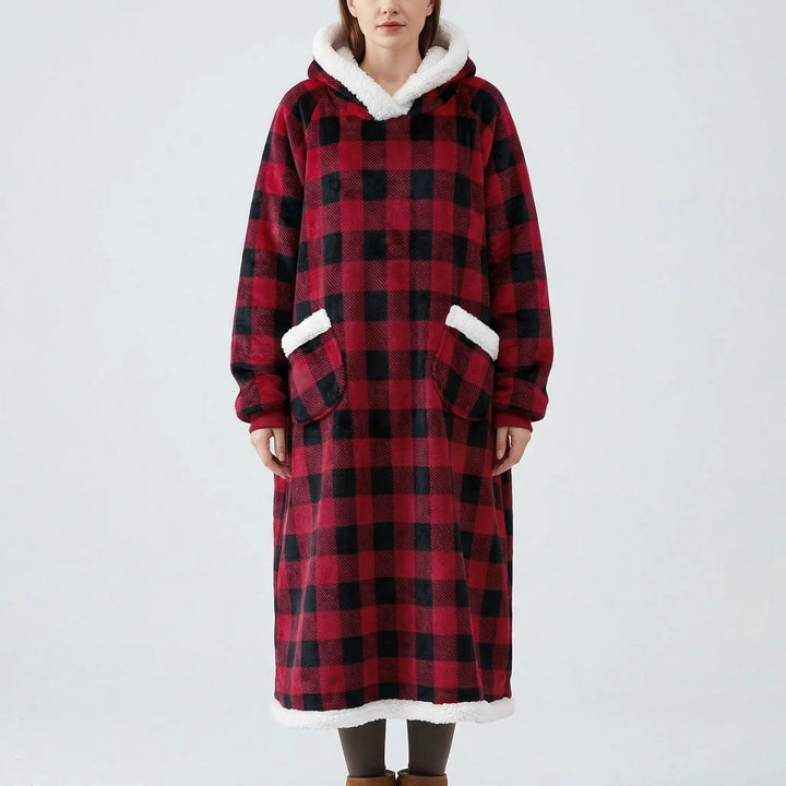 Relaksujący koc oversize z kapturem Lola. Wygodny loungewear na domowe wieczory, z ciepłą kieszenią na dłonie.