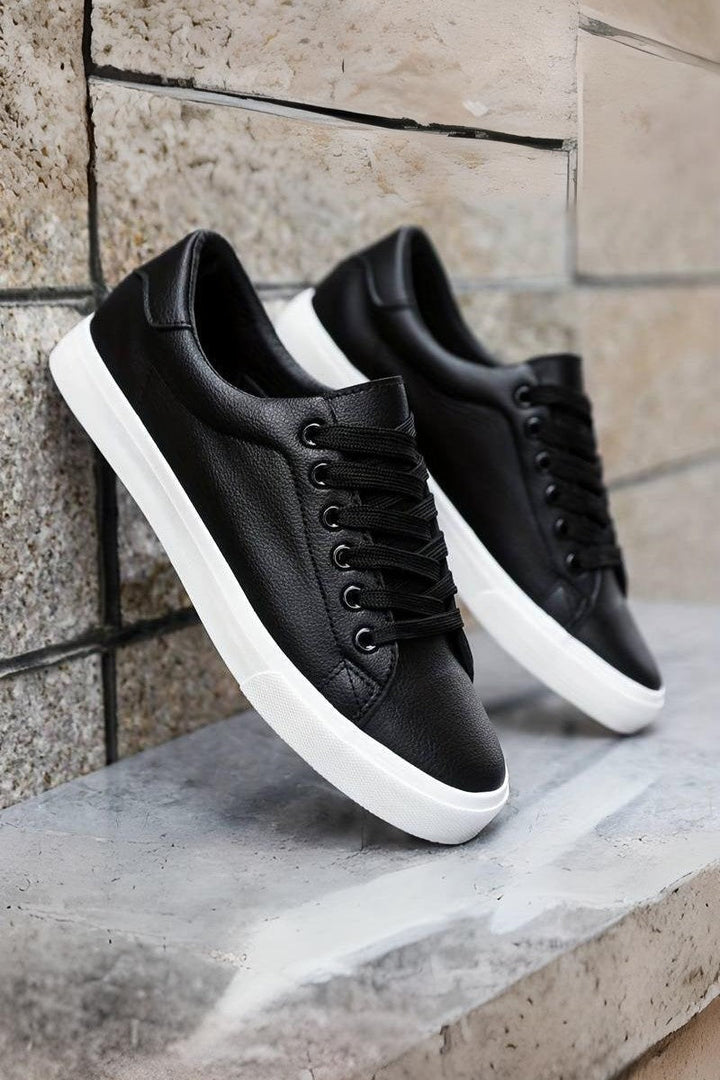 Para męskich sneakersów Oliwier. Białe i czarne, uniwersalne, eleganckie obuwie na wiosnę i lato.