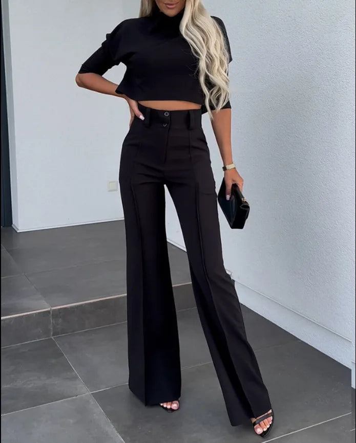 Wizytowy komplet damski: krótki top i szerokie spodnie z wysokim stanem. Rękaw 3/4, minimalistyczny look.