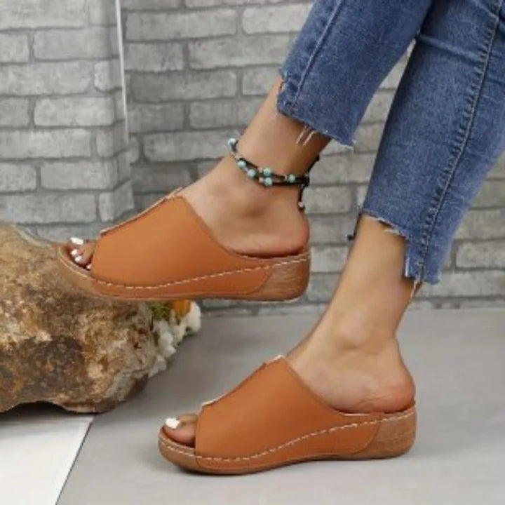 Kobieta nosząca stylowe, wygodne letnie sandały na platformie. Damskie buty slip-on na co dzień.
