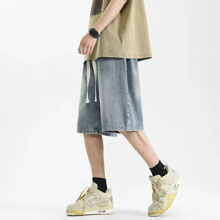 Detale: Tylna kieszeń męskich długich szortów baggy, spranych. Komfortowy styl streetwear na lato.