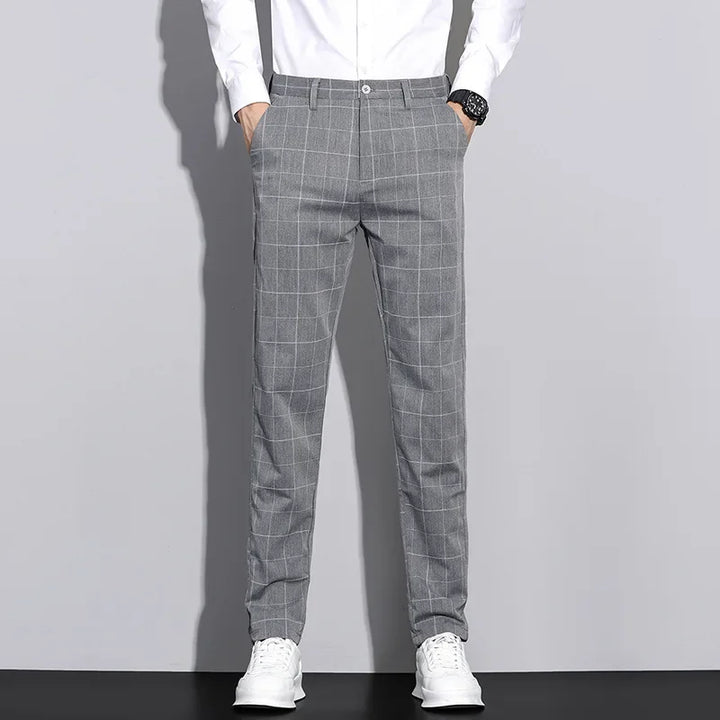 Mężczyzna w modnych, eleganckich spodniach męskich z liniowym wzorem, w stylizacji smart casual.