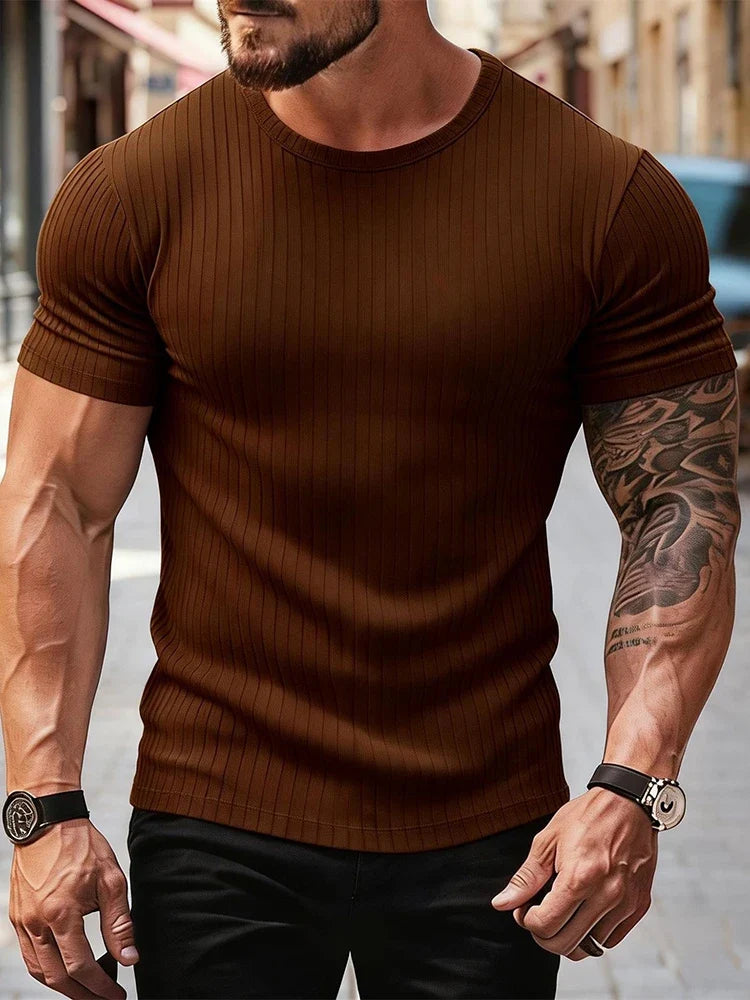 Mężczyzna w stylowym prążkowanym t-shircie z krótkim rękawem. Podkreślający sylwetkę muscle fit.