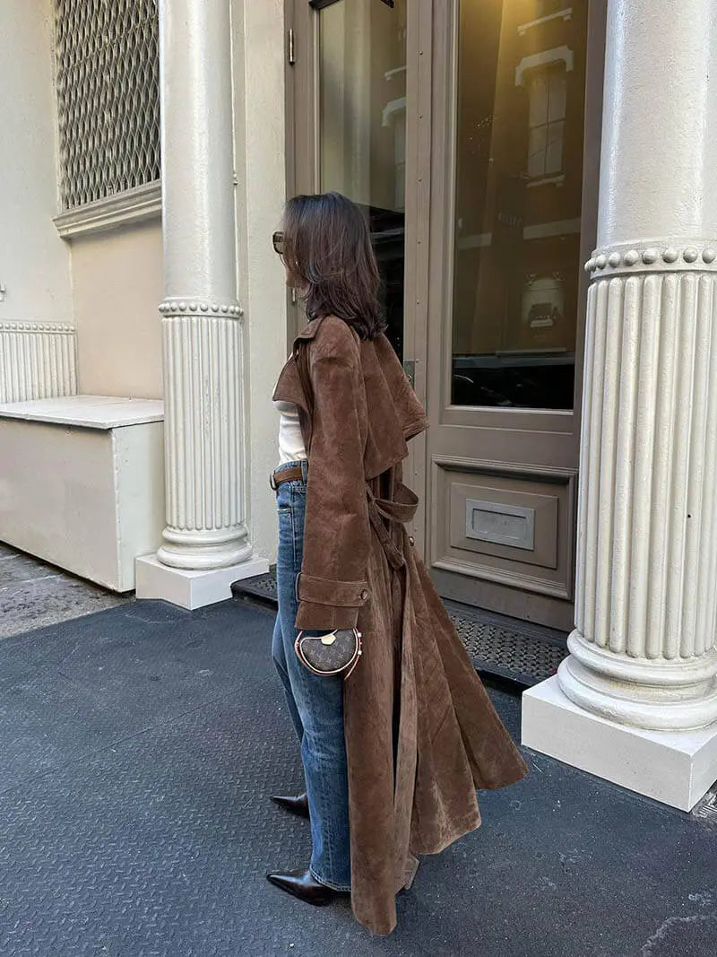 Kobieta w eleganckim, beżowym trenczu damskim z paskiem, klasyczna odzież wierzchnia na wiosnę.
