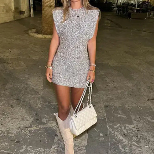 Tył srebrnej sukienki wieczorowej z cekinami, podkreślający dopasowany krój i eleganckie wykończenie.