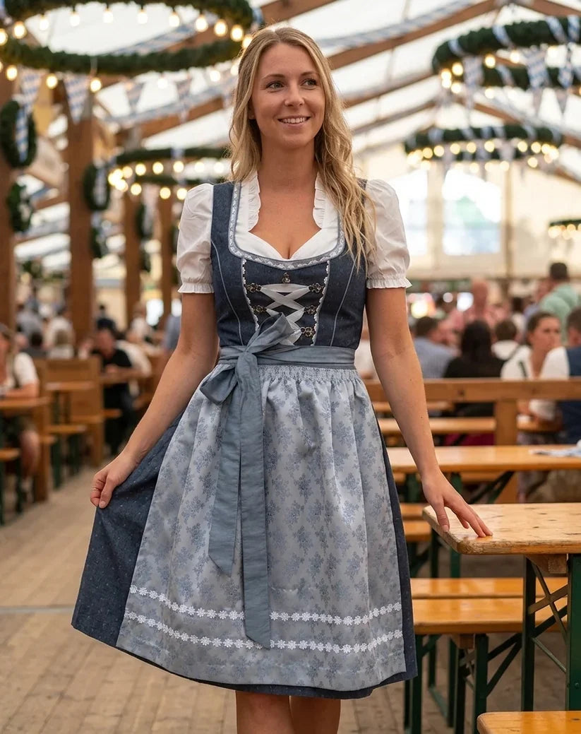 Tradycyjny damski strój ludowy dirndl: szara sukienka, biała bluzka i zielony fartuszek bawarski.