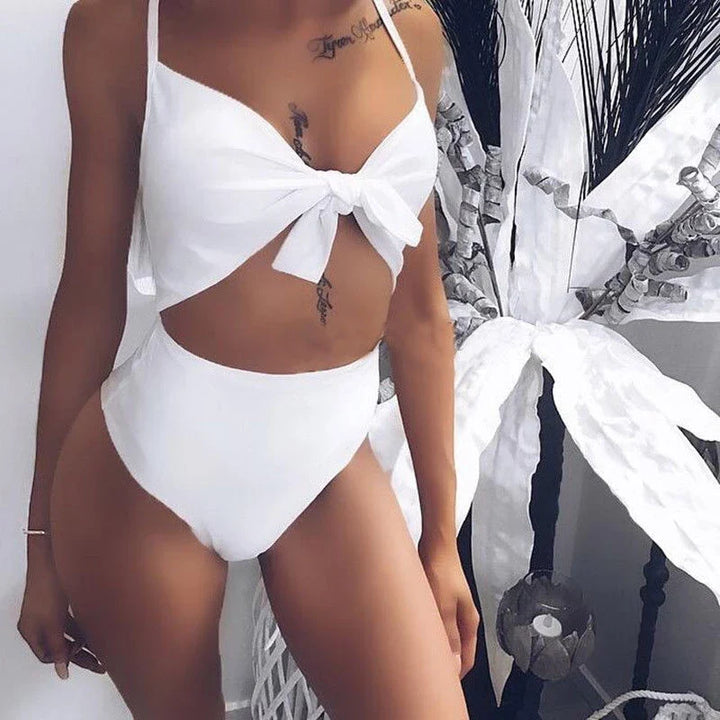 Damskie monokini na plażę, z oryginalnym wycięciem w talii i subtelną kokardą, podkreślające figurę.