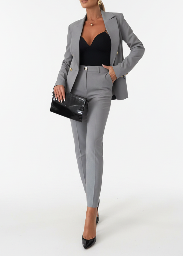 Damski garnitur biznesowy slim fit na modelce siedzącej. Komfort i elegancja w biurowych stylizacjach.