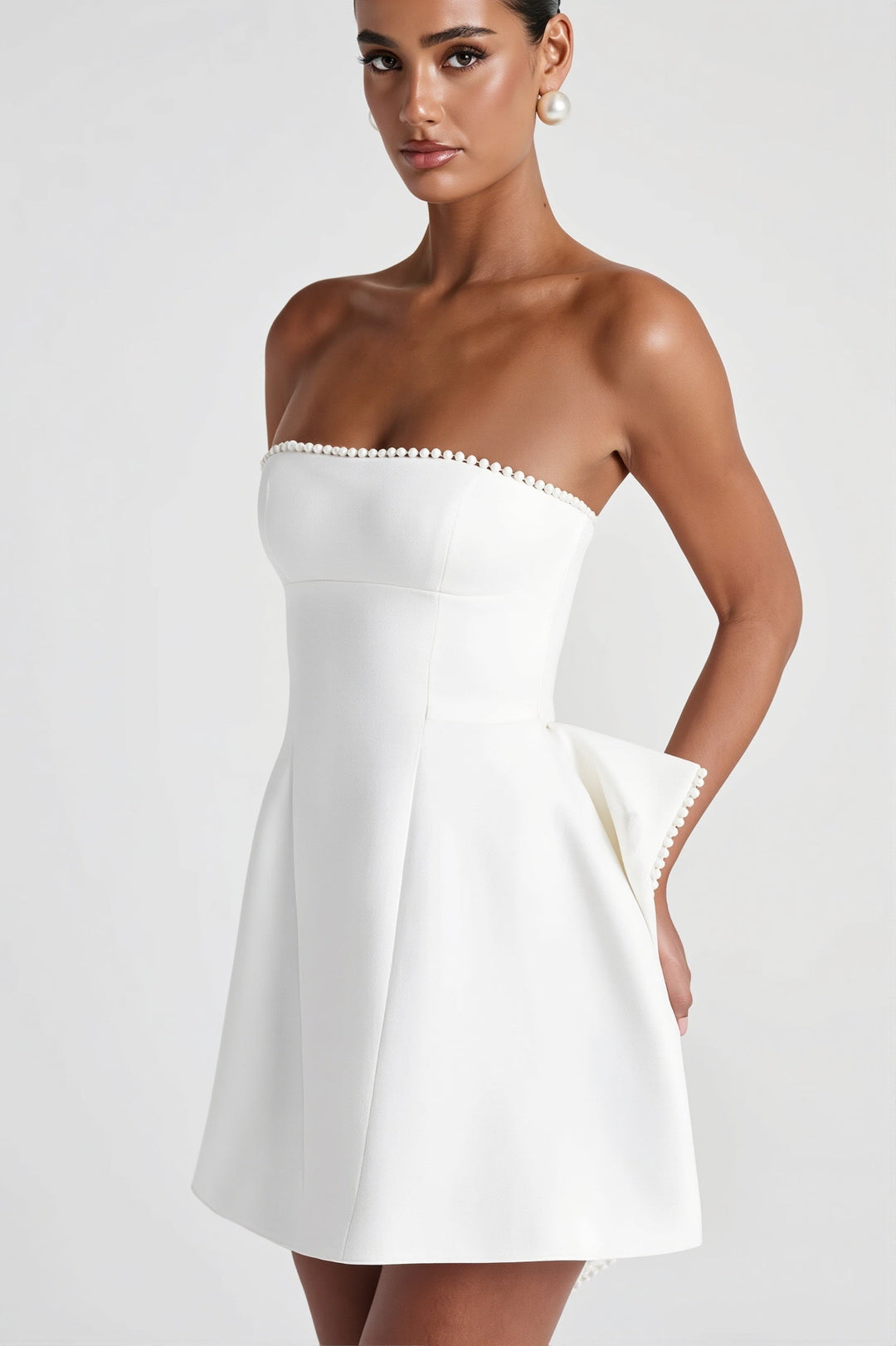 Elegancka wieczorowa sukienka mini bandeau z kokardą. Bez ramiączek, idealna na letnie przyjęcia.