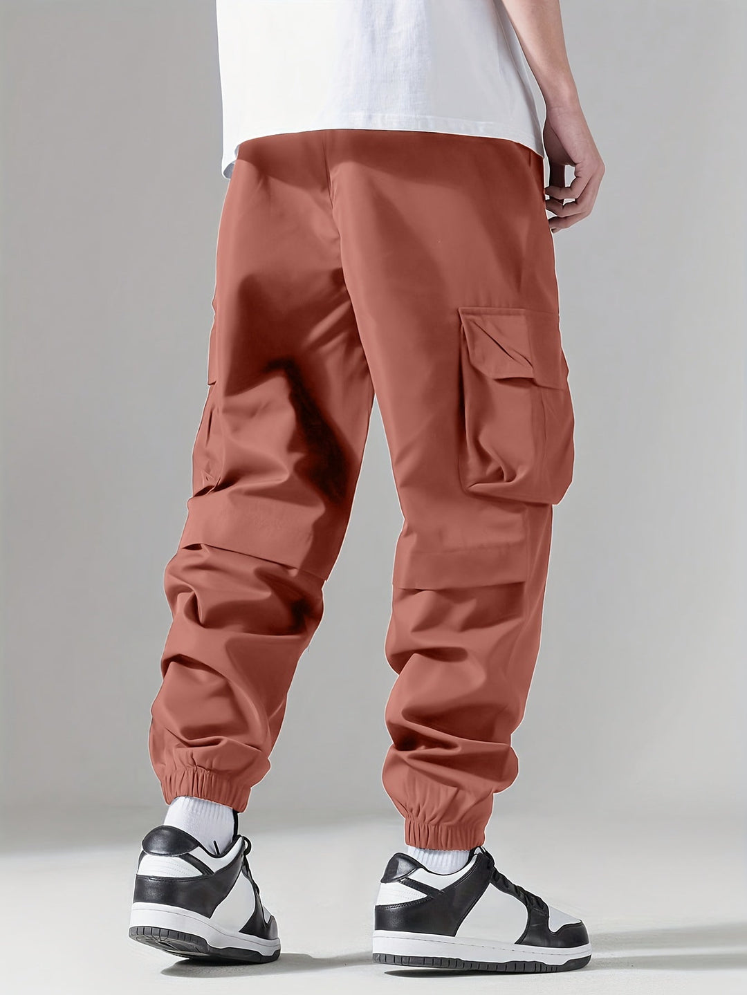 Tył męskich spodni cargo joggerów, z widocznymi kieszeniami, styl streetwear.