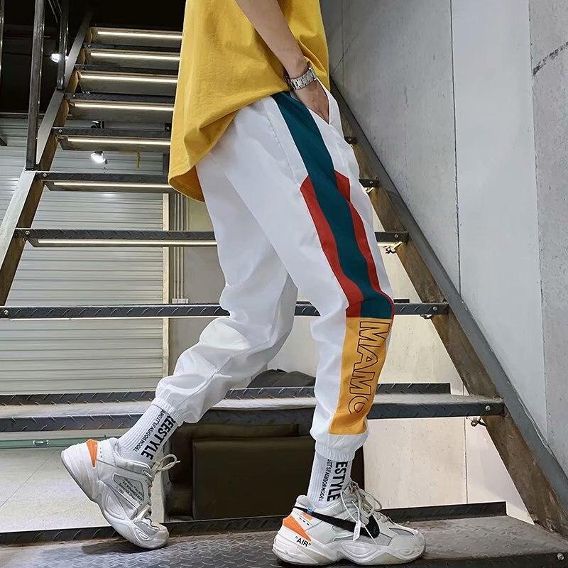 Czarne i białe męskie bojówki ze wzorem geometrycznym. Modne spodnie streetwear z licznymi kieszeniami.