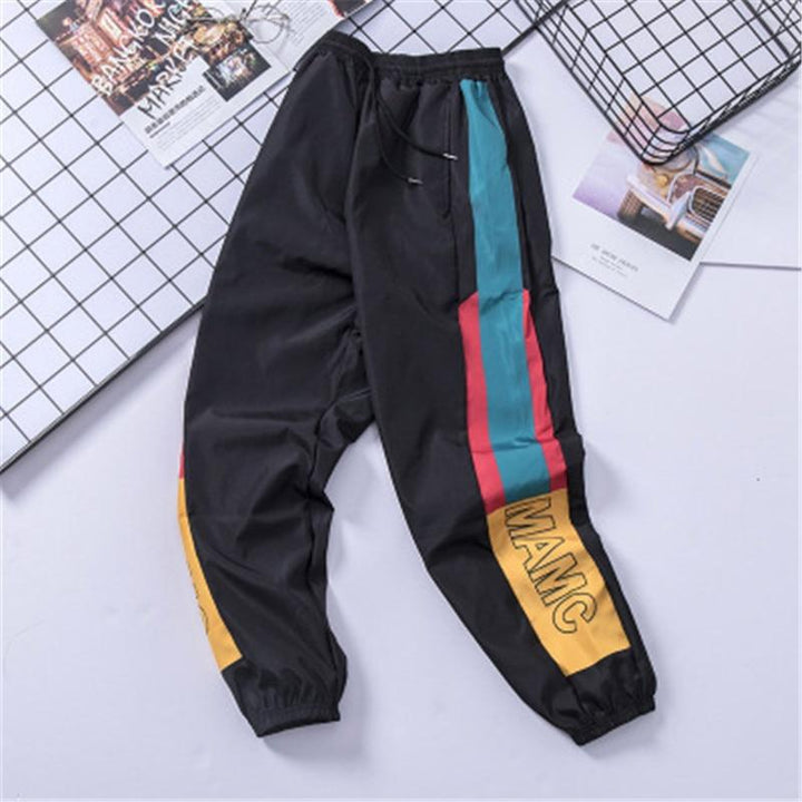 Modne męskie bojówki z unikalnym geometrycznym wzorem. Czarne spodnie z kieszeniami, luźny krój dla stylu streetwear.