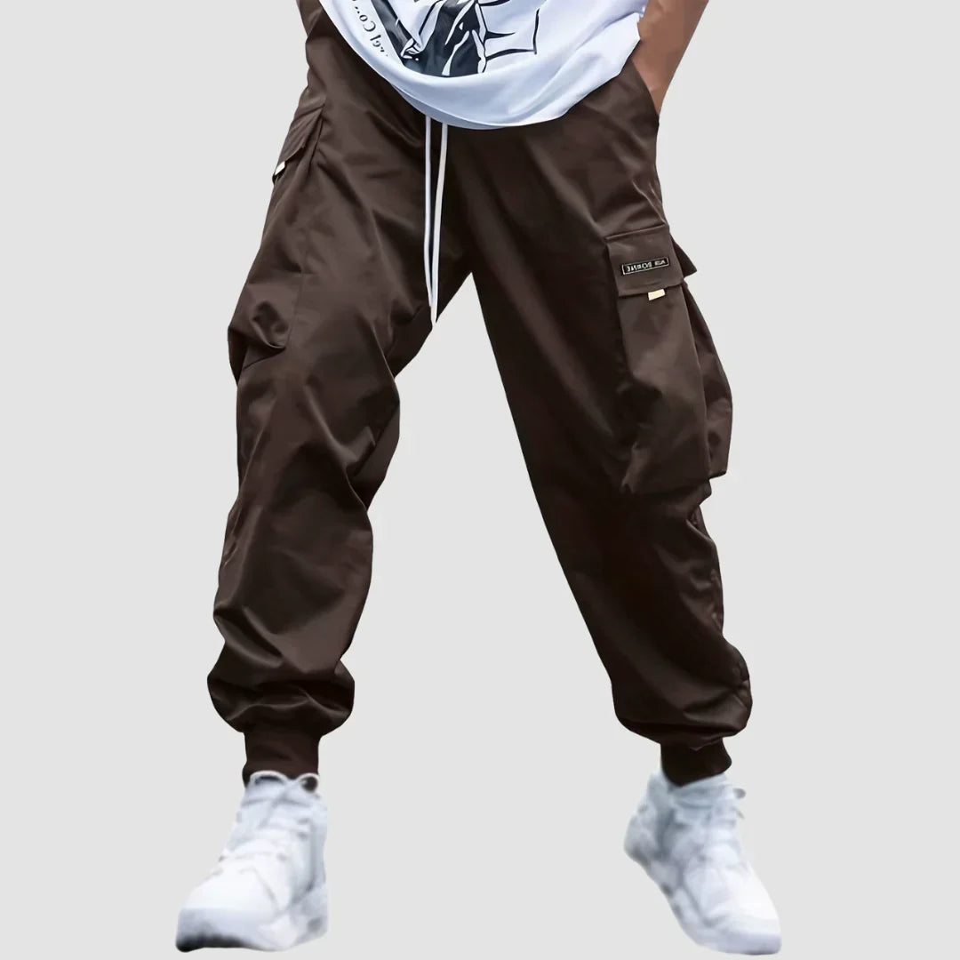 Mężczyzna prezentujący dopasowanie i pas spodni cargo męskich. Styl streetwear, wygoda i funkcjonalność.