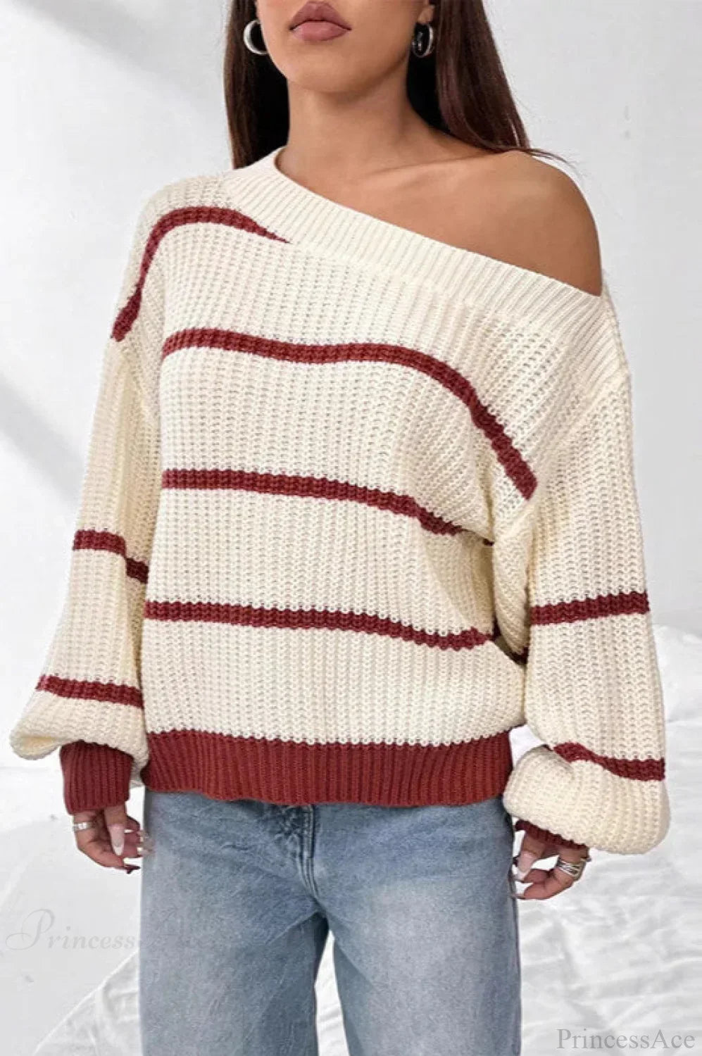 Elegancki sweter damski w paski z odkrytymi ramionami. Luźny fason, bufiaste rękawy z poliestru.