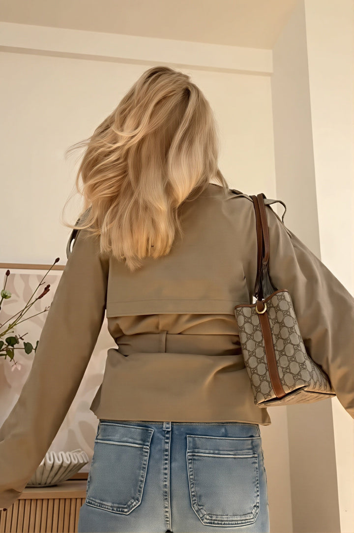 Stylowy krótki trencz damski khaki z paskiem. Dwurzędowa kurtka przejściowa, idealna do miejskiego looku.
