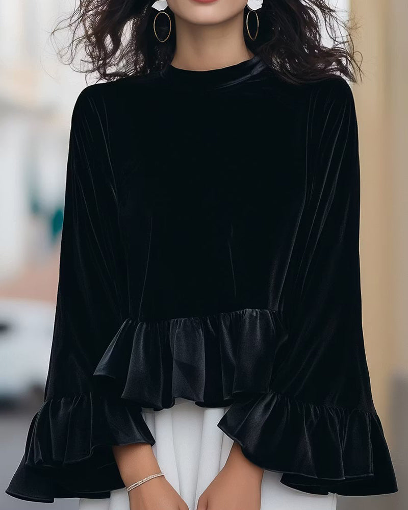 Elegancka damska aksamitna bluzka z falbanami, okrągłym dekoltem i modnymi rozszerzanymi rękawami. Idealna na jesień.