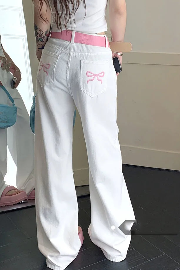 Białe jeansy damskie wide leg z haftem kokard. Luźny fason, wysoki stan. Idealne na co dzień.