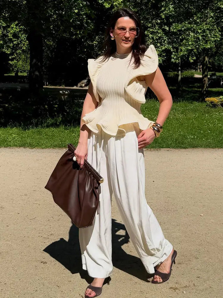 Modna damska bluzka bezrękawnik z falbaną, dopasowany krój, idealna do streetstyle.