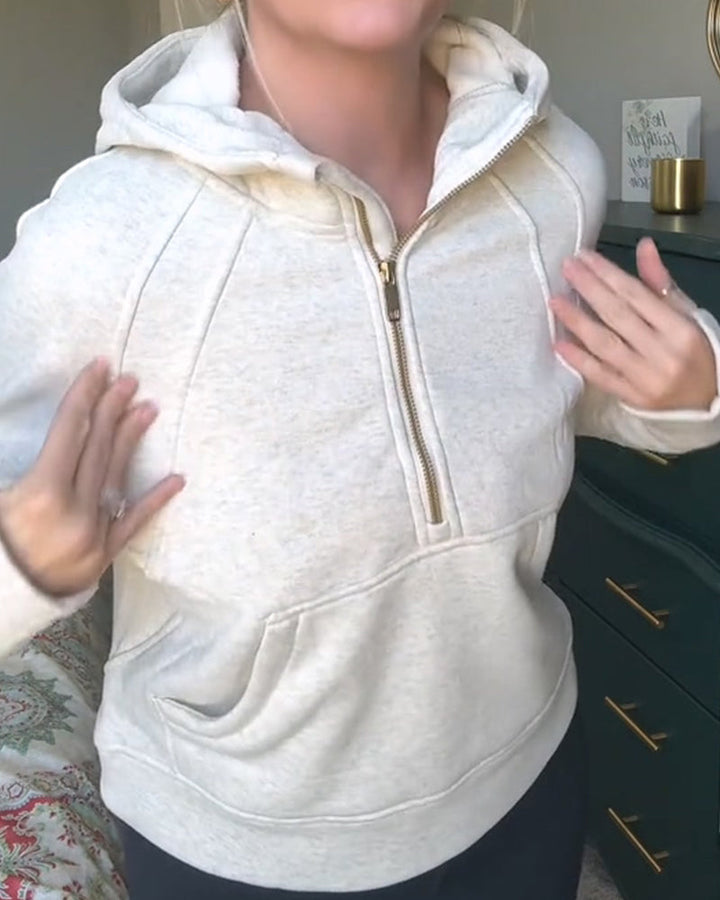 Model w casualowej bluzie unisex z kapturem, na zamek, z bawełny, w kolorze złamanej bieli, do codziennych stylizacji.