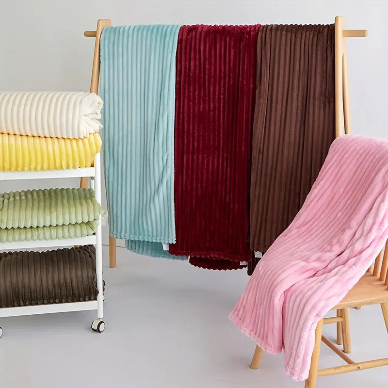 Miękki koc flanelowy w szerokie prążki, tekstylia domowe zapewniające komfort i design w salonie.