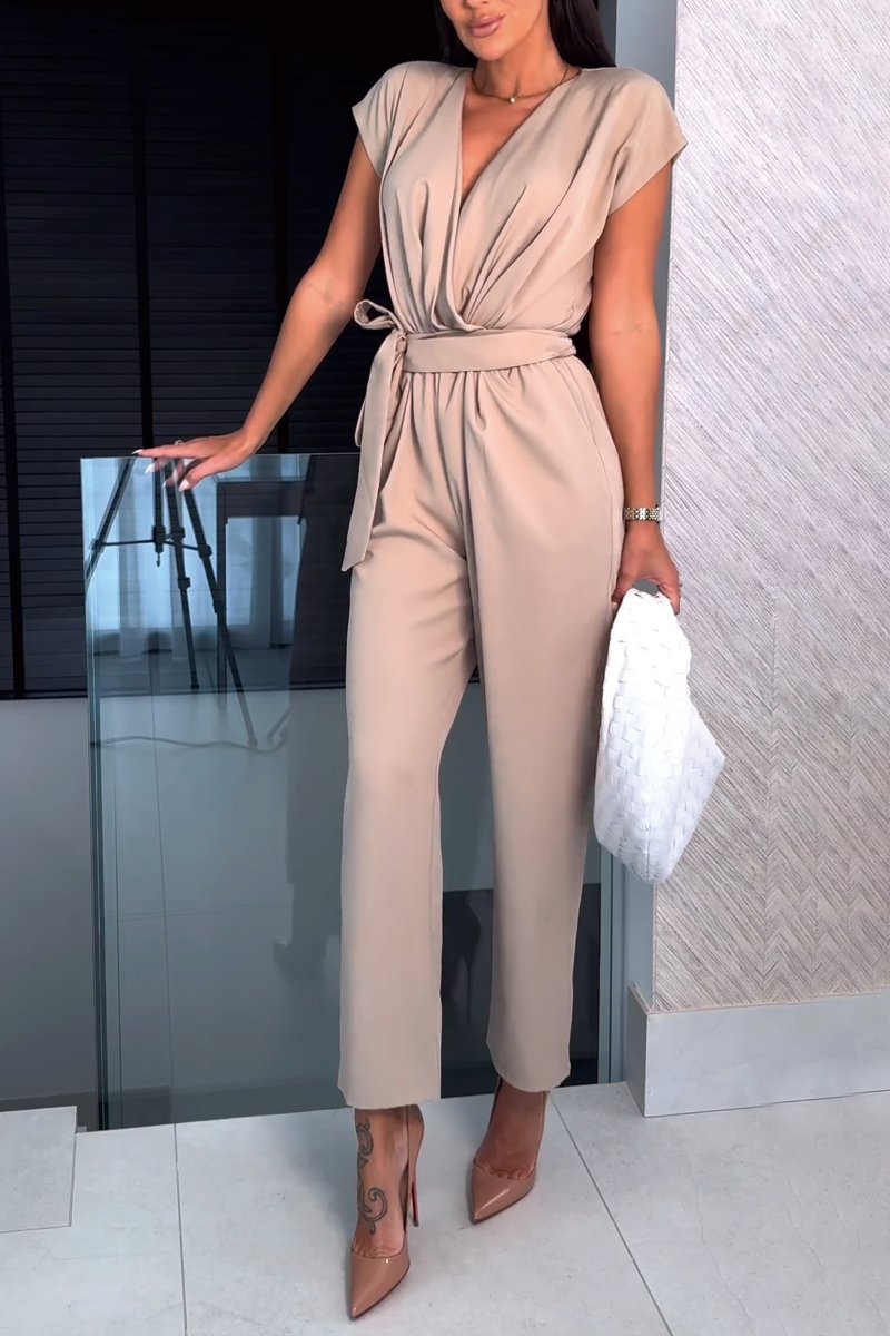 Elegancki letni kombinezon damski z paskiem. Stylowy luźny fason na lato, idealny dla modnej kobiety. Odzież casual.