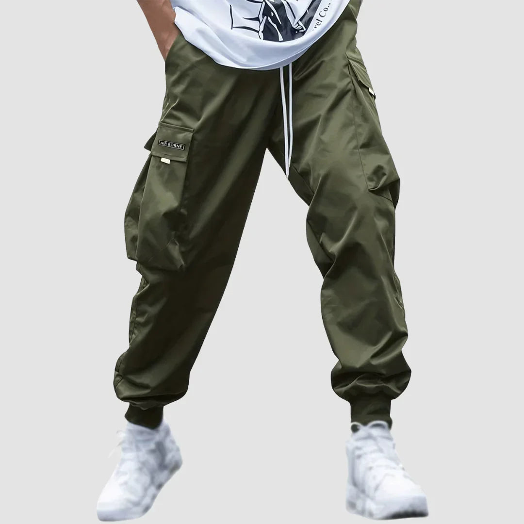 Mężczyzna w modnych spodniach cargo męskich w ruchu. Casualowy look, komfortowe na co dzień, kolor granatowy.